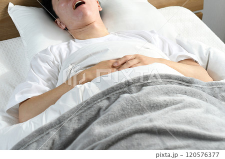 ベッドの上で口を開けて寝るアジア人男性 ベッドの上で口を開けて寝るアジア人男性 120576377