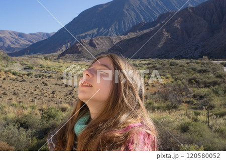 Teenager breathing in the fresh mountain air. Purmamarca, Jujuy, Arg. 120580052