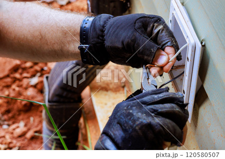 Installation of electrical wires to new outlets requires precision meticulous work 120580507