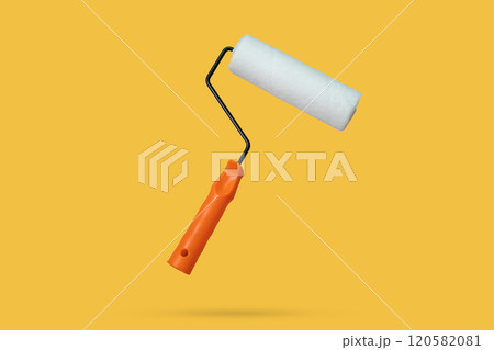 white paint roller floated on yellow background white paint roller floated on yellow background 120582081
