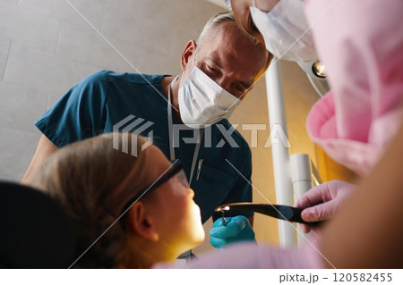 Dentist Examining Child's Teeth During Dental Checkup 120582455