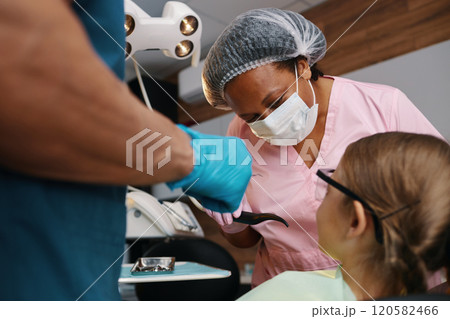 Dental Professional Treating Patient in Clinic Setting Dental Professional Treating Patient in Clinic Setting 120582466