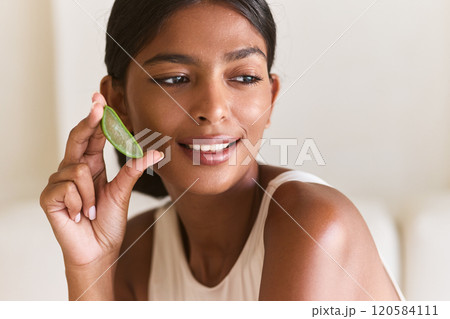 Face Rejuvenation. Woman Holding Aloe Vera Slice, Displaying Natural Beauty Face Rejuvenation. Woman Holding Aloe Vera Slice, Displaying Natural Beauty 120584111