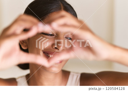 Woman Smiling With Heart Gesture Celebrating Happiness and Joyful Expressions 120584128
