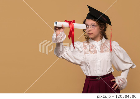 Graduate in cap and gown holding diploma scroll 120584580
