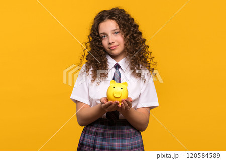 Girl holding a yellow piggy bank Girl holding a yellow piggy bank 120584589