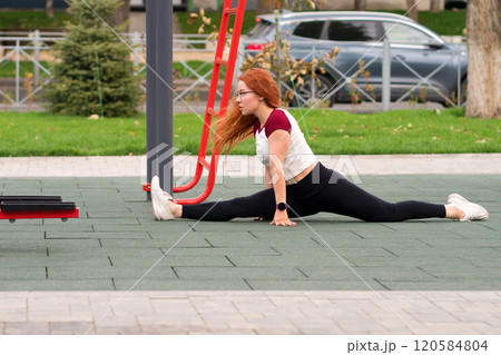 Woman performing outdoor stretching routine 120584804