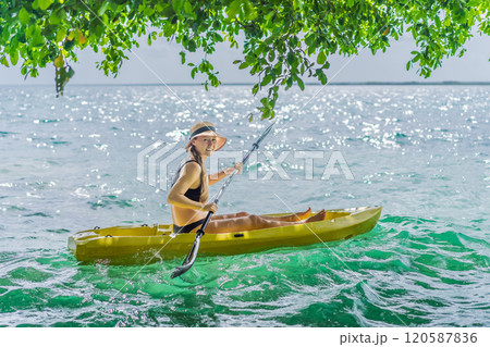 Woman kayaking on Bacalar Lake in Mexico. Adventure tourism in Quintana Roo, outdoor exploration, and water activities concept 120587836