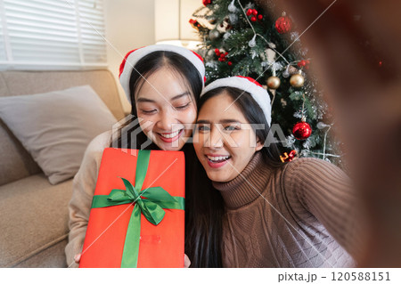 Joyful Young Couple Celebrating Christmas Together with Gifts and Festive Cheer in Cozy Home Setting 120588151