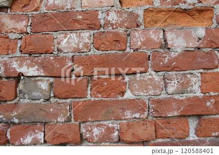Red brick wall with remnants of cement, cement, mortar. Brutal construction background 120588401