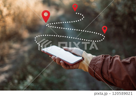 Woman consulting smartphone in the forest to avoid getting lost. Travel and adventure concept Woman consulting smartphone in the forest to avoid getting lost. Travel and adventure concept 120589021