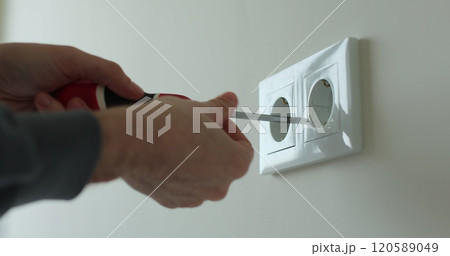 Man hands of electrician dismantling old socket using screwdriver. Replacing electrical outlet. Installing. Repair. Electricity. Man hands of electrician dismantling old socket using screwdriver. Replacing electrical outlet. Installing. Repair. Electricity. 120589049