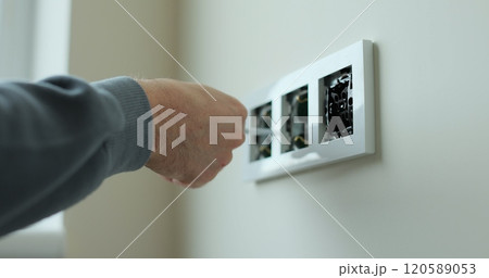 Electrician installing a wall socket. Installing electrical wall outlets with a screwdriver in a new home. Electrician installing a wall socket. Installing electrical wall outlets with a screwdriver in a new home. 120589053