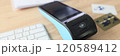 Portable terminal and bank credit cards lie on wooden table 120589412