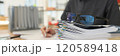 Glasses put on stack of folders with working documents 120589418