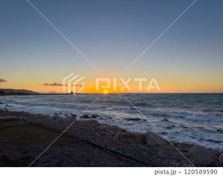 Sunset Over the Ocean With Waves Crashing on Rocky Shore During Twilight Hours at Coastal Location Sunset Over the Ocean With Waves Crashing on Rocky Shore During Twilight Hours at Coastal Location 120589590