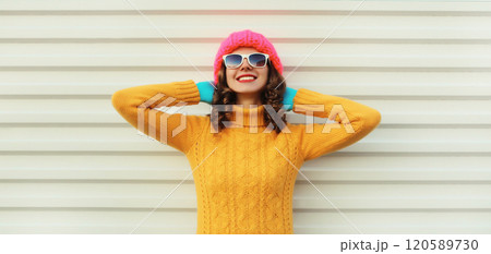 Winter christmas portrait of happy relaxed woman smiling in yellow sweater, hat on white background Winter christmas portrait of happy relaxed woman smiling in yellow sweater, hat on white background 120589730
