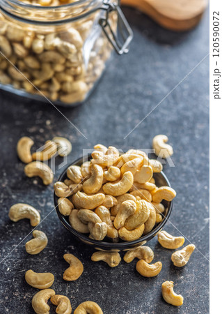 Roasted cashew nuts in bowl on black table. Roasted cashew nuts in bowl on black table. 120590072