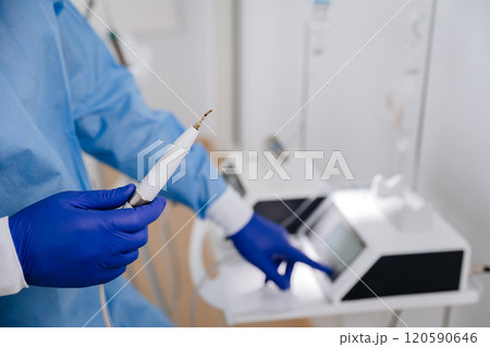 Dental professional preparing ultrasonic scaler for teeth cleaning in a modern dental clinic 120590646