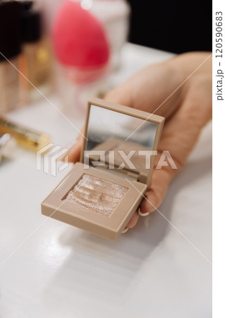 Close up of a shimmering gold eyeshadow palette with a built-in mirror for flawless makeup Close up of a shimmering gold eyeshadow palette with a built-in mirror for flawless makeup 120590683