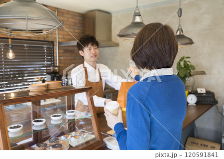 カフェでテイクアウトをする女性 120591841