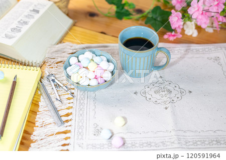 テーブルの上に勉強道具と共に準備されたカラフルなラムネとコーヒー 120591964