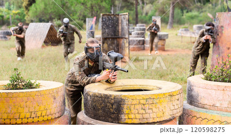Portrait of girl in camouflage on paintball field 120598275