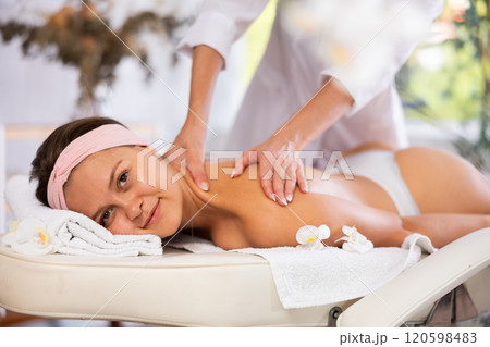 Young woman getting back and shoulder massage Young woman getting back and shoulder massage 120598483