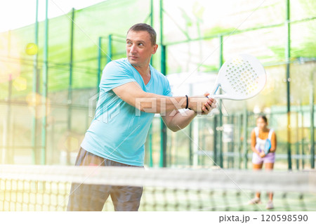 Male padel tennis player training on court 120598590