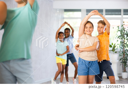 Active preteen children practicing Ballroom dances in pairs in training hall 120598745