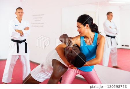 People training martial arts in gym with trainer People training martial arts in gym with trainer 120598758