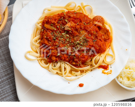 Appetizing spaghetti with sausage served on platter 120598816