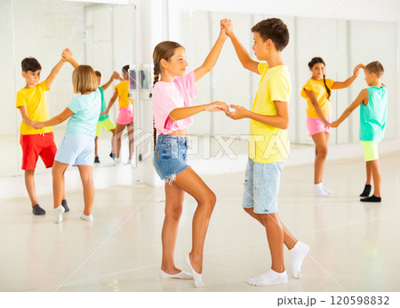 Tweenagers practicing active balroom dances in pairs in choreographic studio Tweenagers practicing active balroom dances in pairs in choreographic studio 120598832