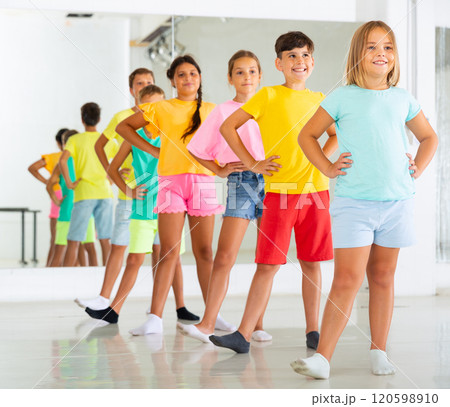 Cheerful tweens lined up one after another practicing folk dance 120598910