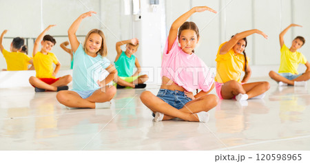 Young boys and girls sitting and training ballet moves 120598965