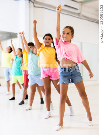 Boys and girls standing in row in dance room 120599152