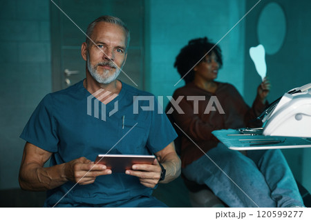 Portrait of Smiling Man Holding Tablet in an Office Portrait of Smiling Man Holding Tablet in an Office 120599277