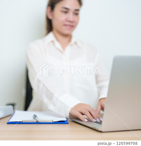 Asian woman working with computer laptop, female businesswoman reading and writing report or sign contract with documents folder stack at home or office. business financial concept Asian woman working with computer laptop, female businesswoman reading and writing report or sign contract with documents folder stack at home or office. business financial concept 120599708