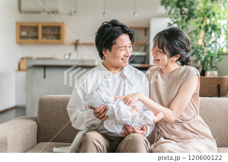 赤ちゃんと出産後の育児休暇を過ごす若い夫婦・親子・家族・ファミリー 120600122