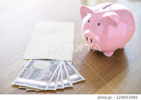 ブタの貯金箱と封筒に入れられたお札（新紙幣） 120601069