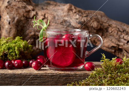 Hot drink with cranberries, lime, and rosemary on a old wooden board. Hot drink with cranberries, lime, and rosemary on a old wooden board. 120602243