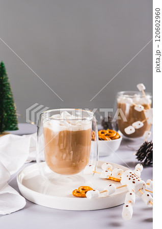 Warm cocoa in cups and snowflakes made of marshmallows and icing on a plate vertical view Warm cocoa in cups and snowflakes made of marshmallows and icing on a plate vertical view 120602960
