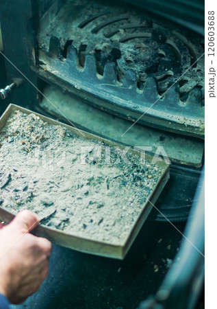 A man cleaning a pellet stove with a brush. Maintenance concept. High quality photo A man cleaning a pellet stove with a brush. Maintenance concept. High quality photo 120603688