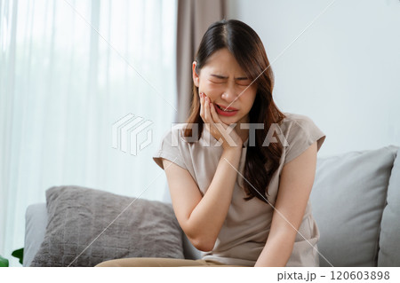 A woman is in pain and is holding her face having a toothache. Healthcare and medical concept. 120603898