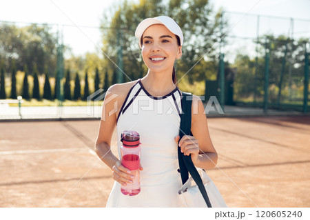 Cute female tennis player with a bottle of water after the game 120605240