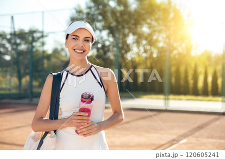 Cute female tennis player with a bottle of water after the game Cute female tennis player with a bottle of water after the game 120605241