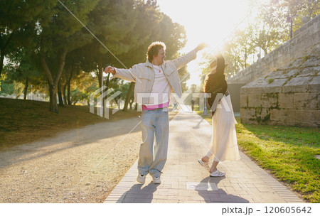 A Joyful Couple Enjoying a Blissful Sunlit Stroll Together in the Beautiful Outdoors of Nature A Joyful Couple Enjoying a Blissful Sunlit Stroll Together in the Beautiful Outdoors of Nature 120605642