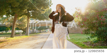 Enjoying a Sunlit Stroll in Nature A Beautiful Combination of Fashion and Serenity 120605656