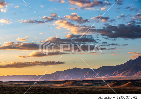 Breathtaking steppe morning landscape with a majestic Tian-Shan mountain backdrop, National nature park of Kazakhstan. 120607542
