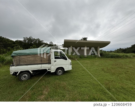 外仕事用の軽トラックが山の平地に停まっている景色 120608459
